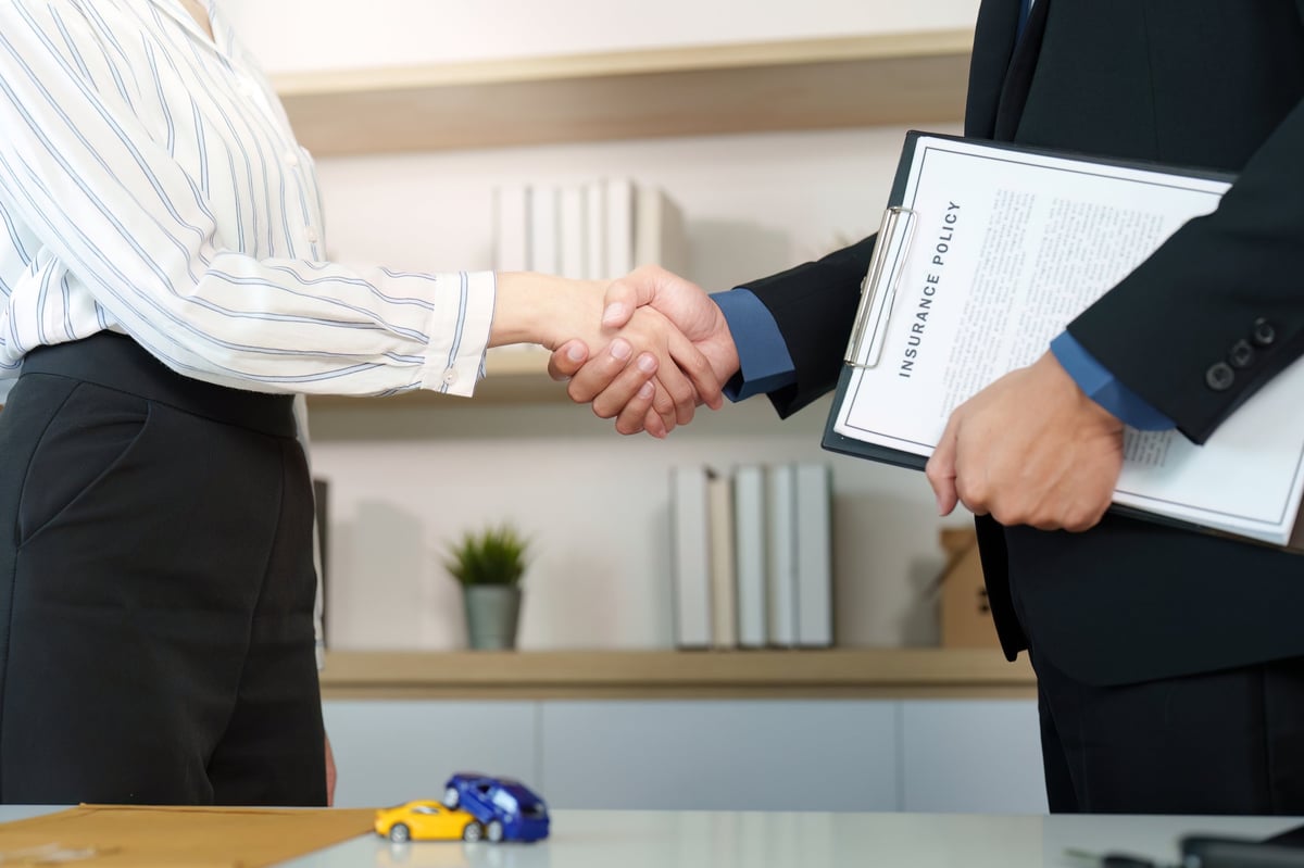 Client and insurance agent shake hands after finalizing an agreement